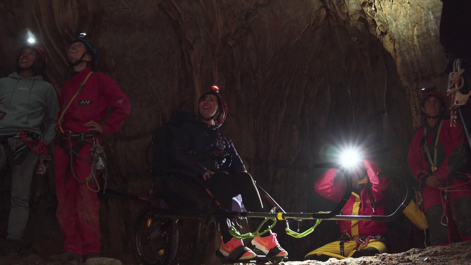 Une civière éclairée à la lampe frontale dans la grotte